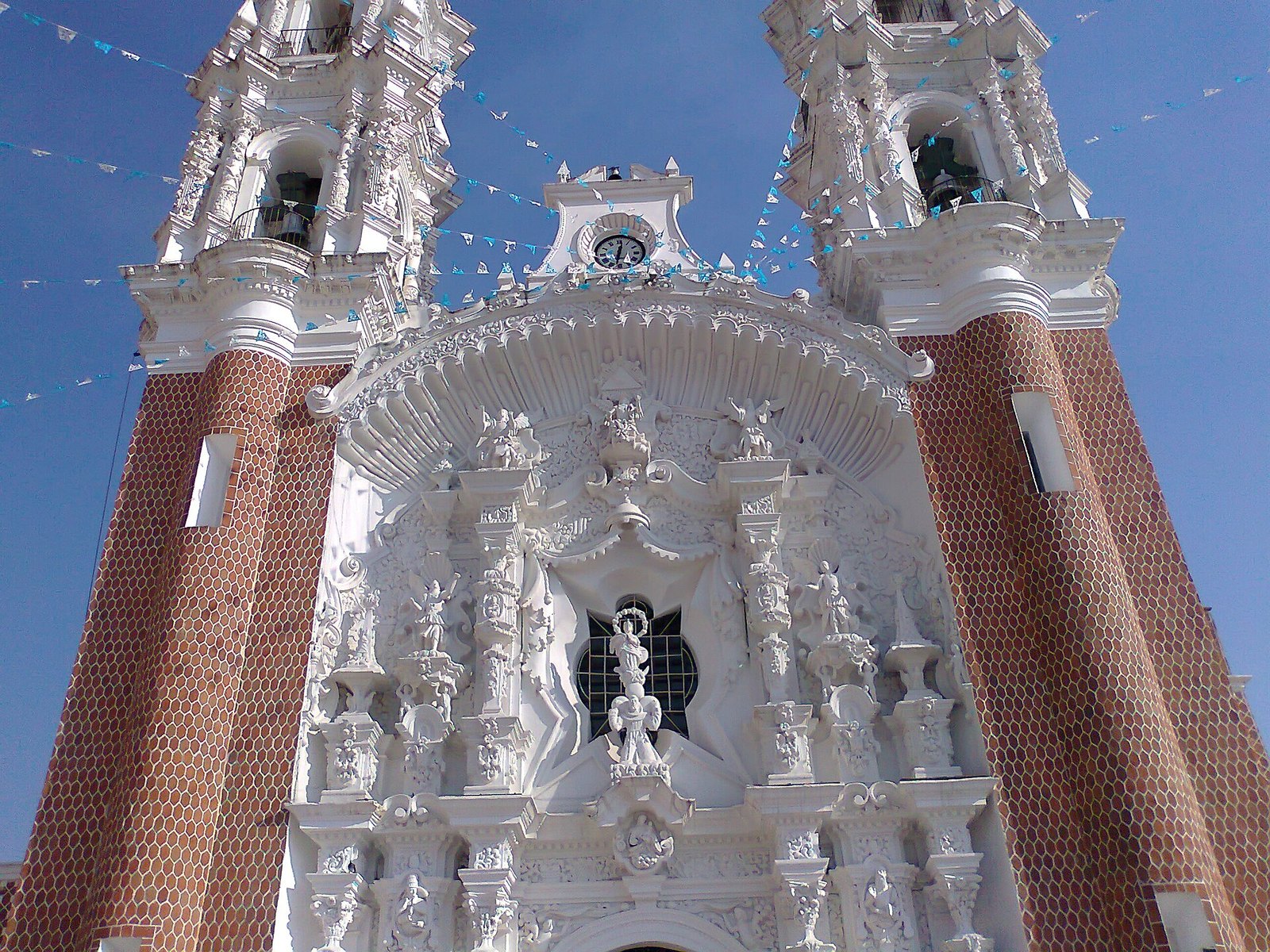 Mặt tiền Vương cung thánh đường Đức Mẹ Ocotlán — kiệt tác baroque Churrigueresque bằng thạch cao trắng giữa hai tháp gạch đỏ, Tlaxcala, Mêhicô